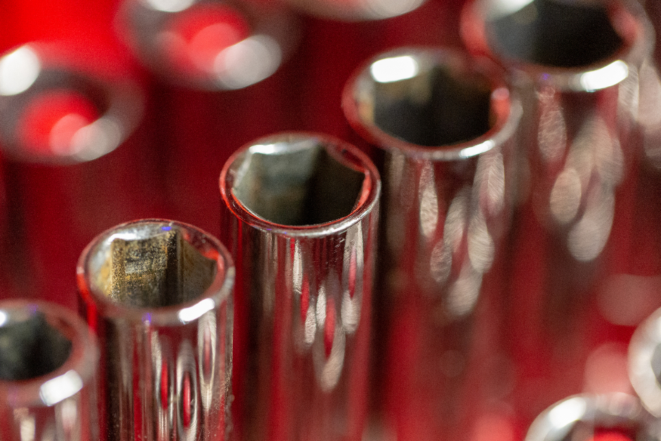 Chromen doppen van een dopsleutelset in close-up tegen een rode achtergrond